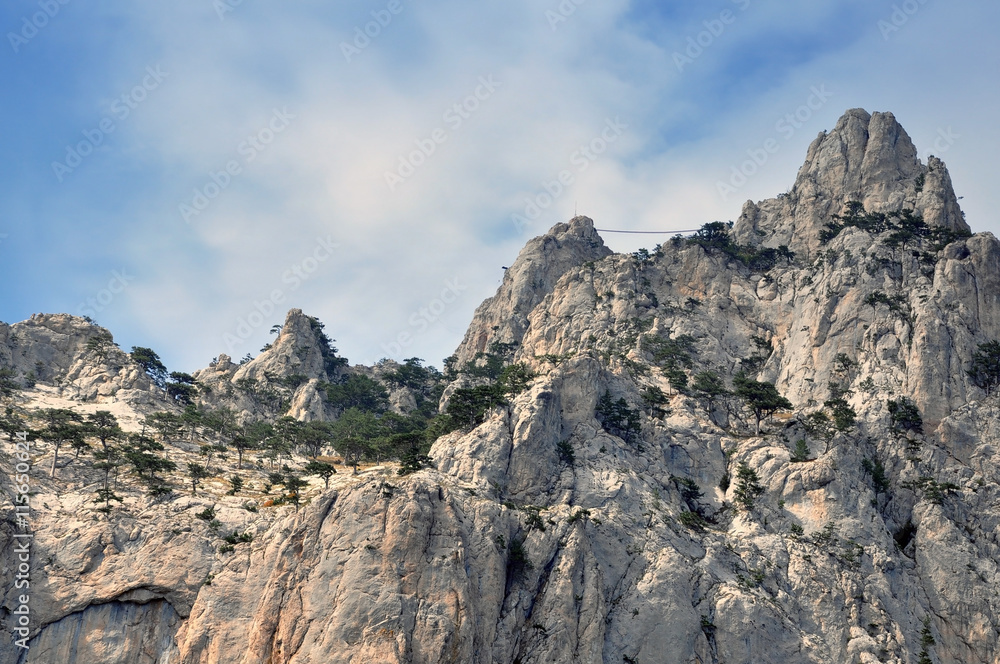 Crimea Mountains. Mountain rocky ridge with peaks against the blue sky in the summer. Horizontal view.