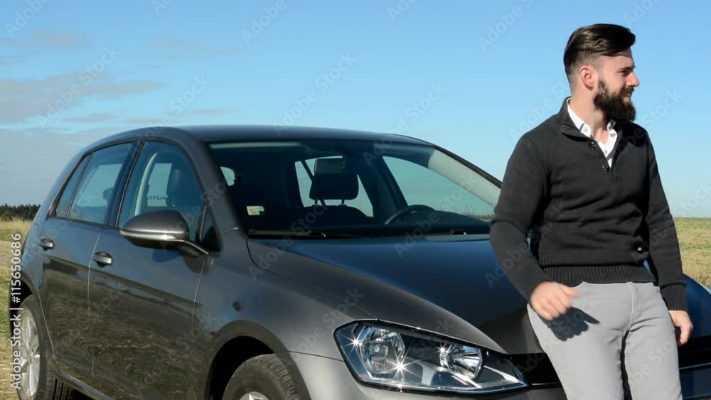 young handsome happy man shows thumb up as agree in the countryside - he stands by his new car - eye contact young handsome happy man shows thumb up as agree in the countryside - he stands by his new car - eye contact