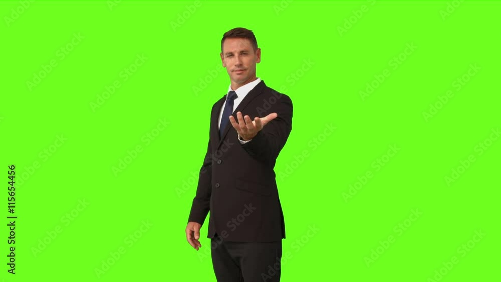 Businessman standing with hand out on green screen background Businessman standing with hand out on green screen background
