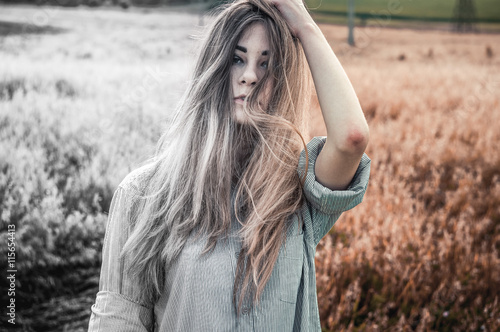 Beautiful and young girl in a man's shirt standing in the field. shirt for the girl. Nature. Wind inflates hair. © Steve Kline