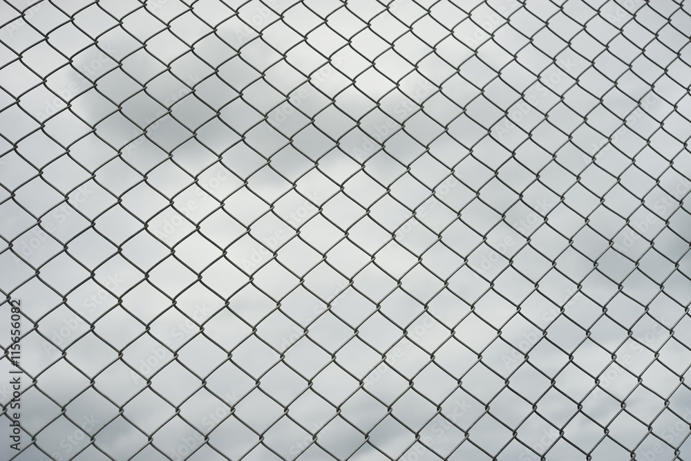 Rusty steel wire mesh fence , cloud in background Rusty steel wire mesh fence , cloud in background