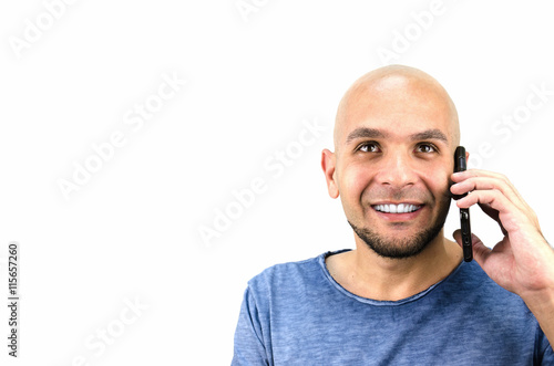 bald-headed man talking on a mobile phone