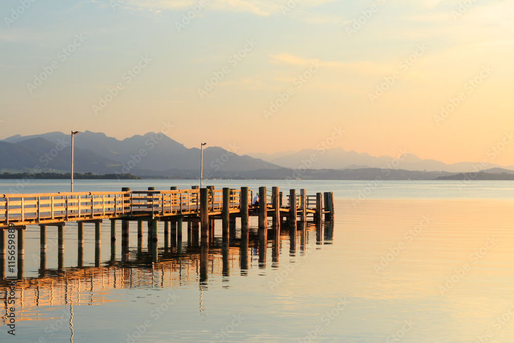 Pier at Chieming Lake Chiemsee at sunset with alpes Pier at Chieming Lake Chiemsee at sunset with alpes