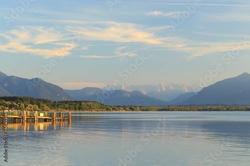 Pier at Chieming Lake Chiemsee at sunset with alpes