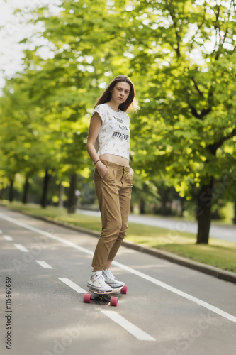 Young girl student model pants shirt and sneakers rides on the b