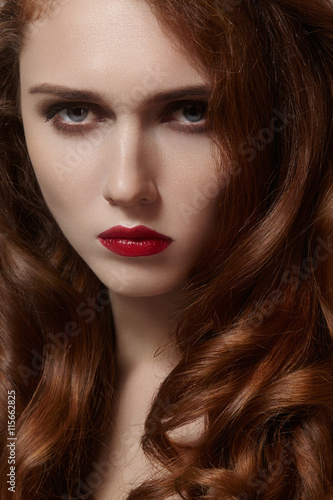 Beautiful young woman with clean skin, shiny red hair, fashion makeup. Glamour make-up, perfect blood lips. Portrait sexy ginger woman with curly hairstyle