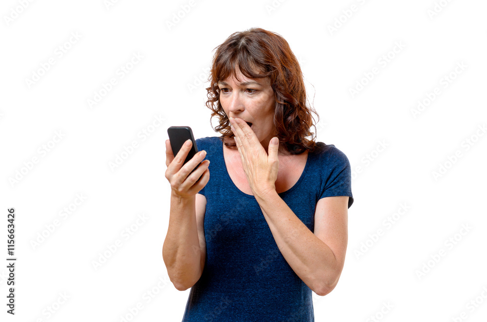 Horrified middle-aged woman looking at her mobile
