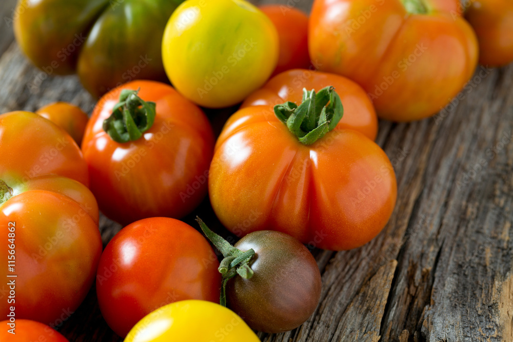 colorful organic tomatoes on wooden surface
