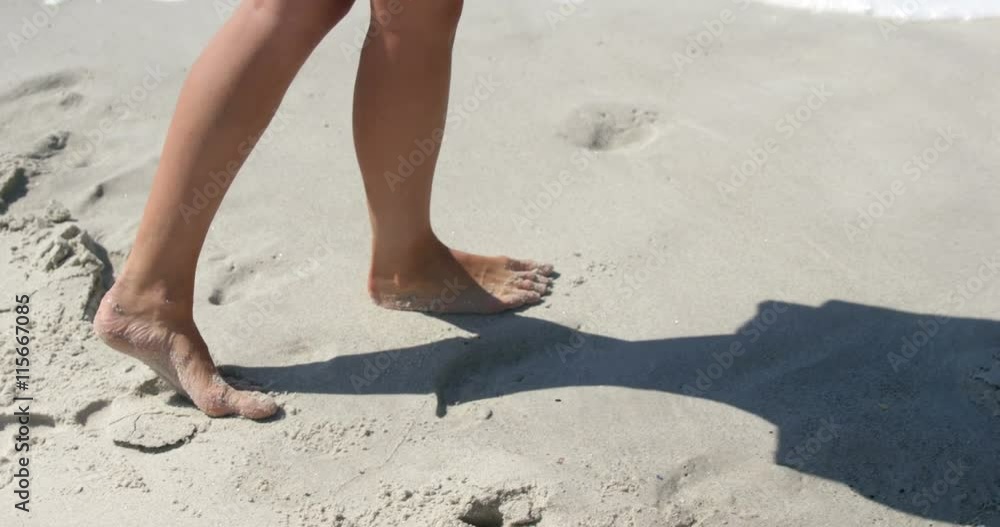 Woman walking on the beach bare footed Woman walking on the beach bare footed