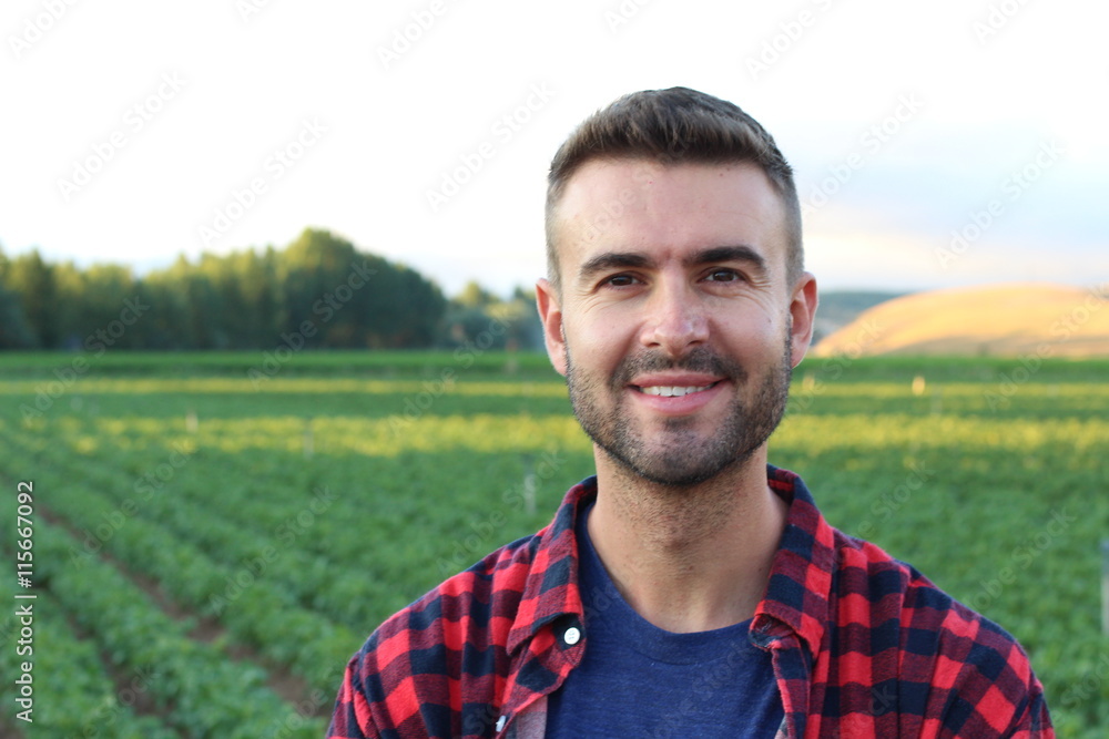 Happy smiling caucasian thirty years old farmer standing proud in front of his fields Happy smiling caucasian thirty years old farmer standing proud in front of his fields