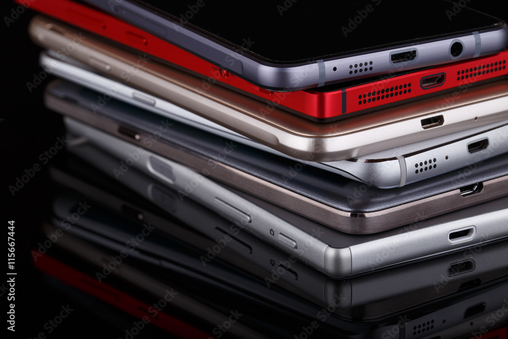 Heap of electronical devices close up - smartphones on black bac Heap of electronical devices close up - smartphones on black bac