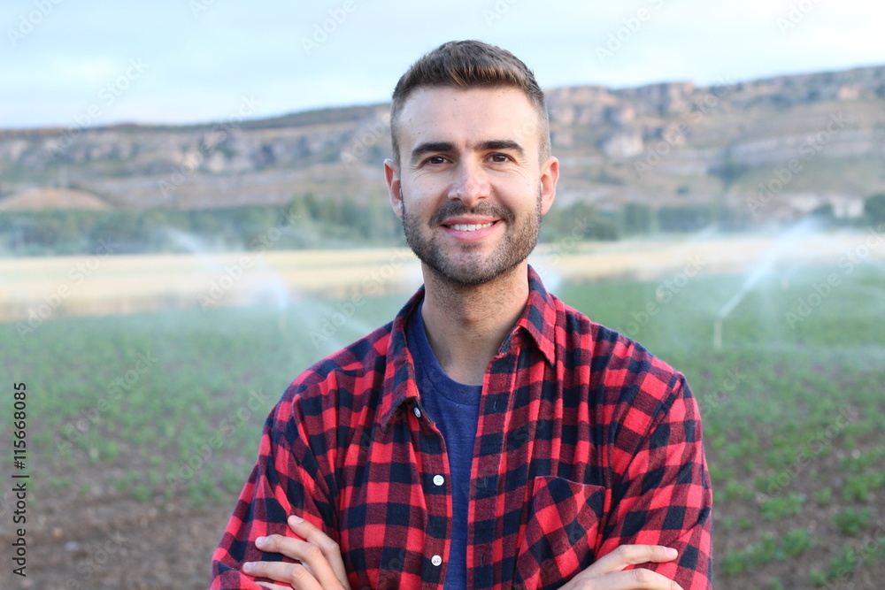 Young happy man smiling at camera in the potato and wheat fields