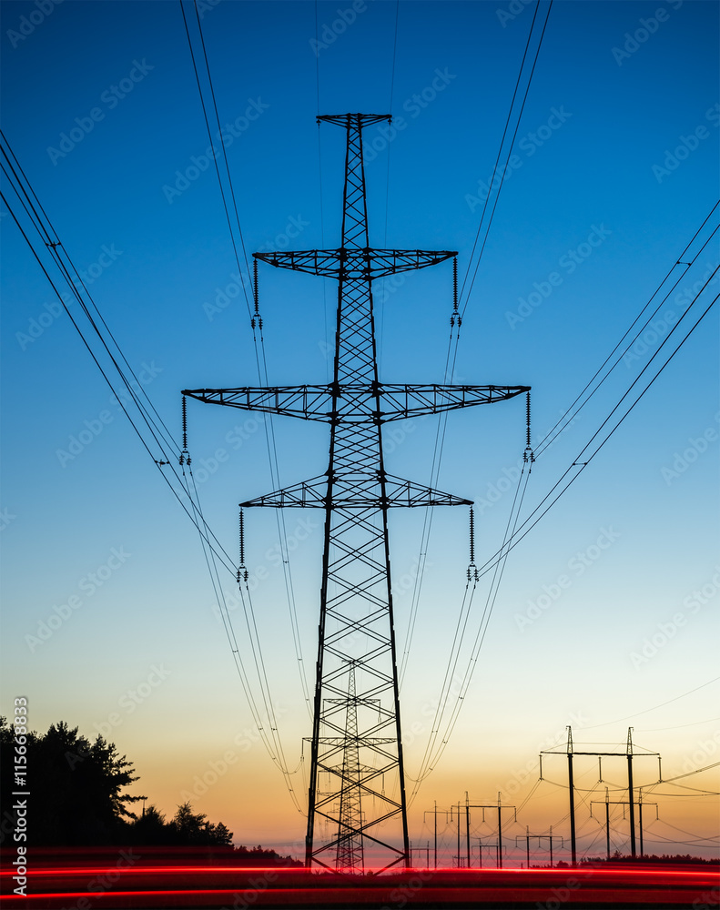 Fototapeta premium High voltage power lines with electricity pylons at twilight