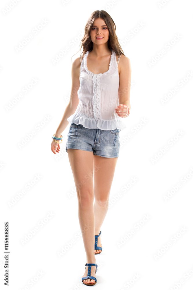 Girl in blouse is walking. Short shorts and sandals. Simple design of summer clothing. Lightness, beauty and comfort. Girl in blouse is walking. Short shorts and sandals. Simple design of summer clothing. Lightness, beauty and comfort.