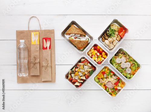 Fotografie Healthy food take away in boxes, top view at wood