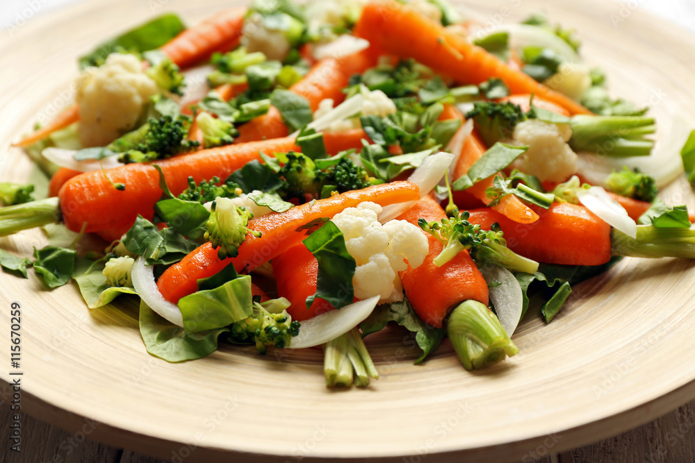 Fresh salad with baby carrots on wooden plate closeup Fresh salad with baby carrots on wooden plate closeup