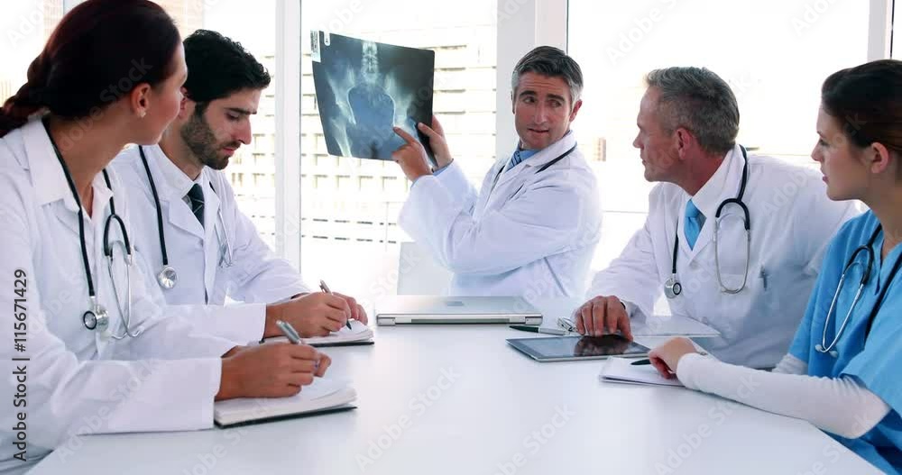 Medical team looking at x-ray during a meeting in the board room at the hospital Medical team looking at x-ray during a meeting in the board room at the hospital