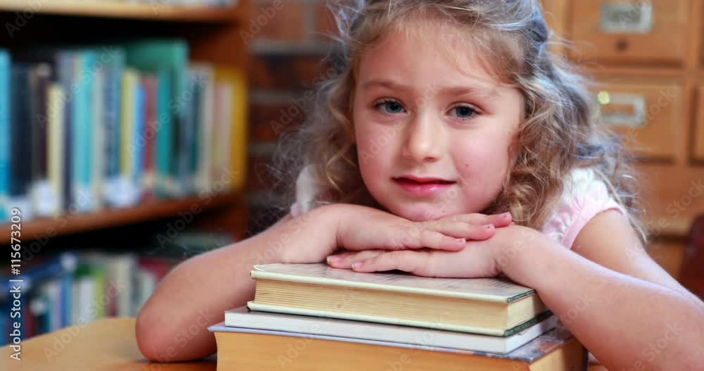 Little girl smiling at camera in the library in elementary school Little girl smiling at camera in the library in elementary school
