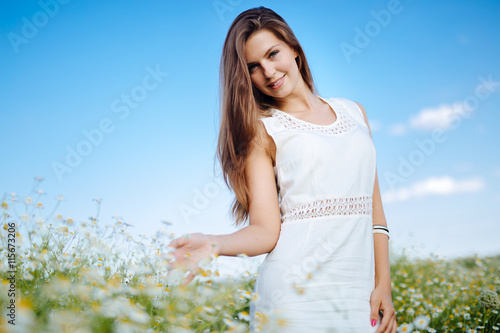 Beautiful woman in chamomile field