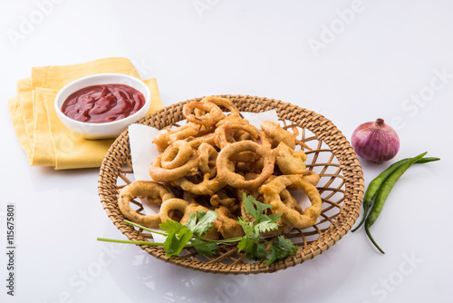 kanda bhaji in marathi or pyaj pakode in hindi or onion pakode, salty and spicy, north indian snacks,asian snacks served in terracotta bowl with tomato ketchup photo
