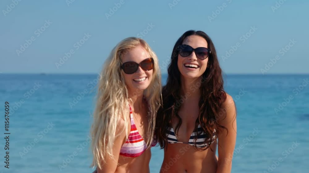 Video of two pretty friends having fun in front of camera at the beach 
