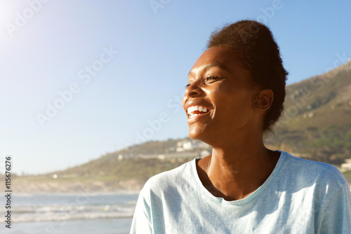 Attractive african woman standing outdoors and laughing