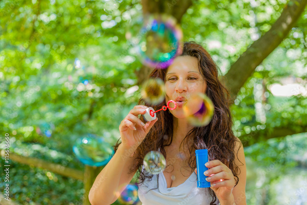 adult woman blowing soap bubbles