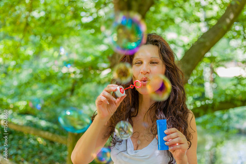 adult woman blowing soap bubbles