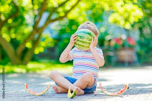 little preschool kid boy eating watermelon in summer