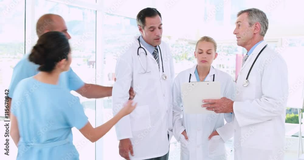Video of doctors looking at clipboard and one of them going with surgeon Video of doctors looking at clipboard and one of them going with surgeon
