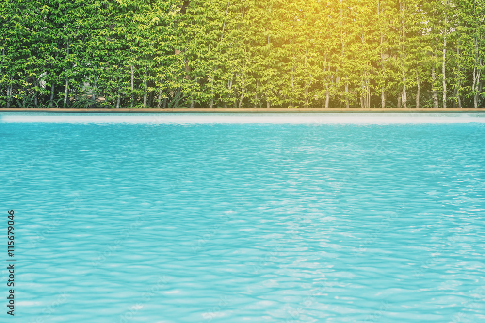 Blue ripped water with green bush at swimming pool, vintage tone, with bright sunlight