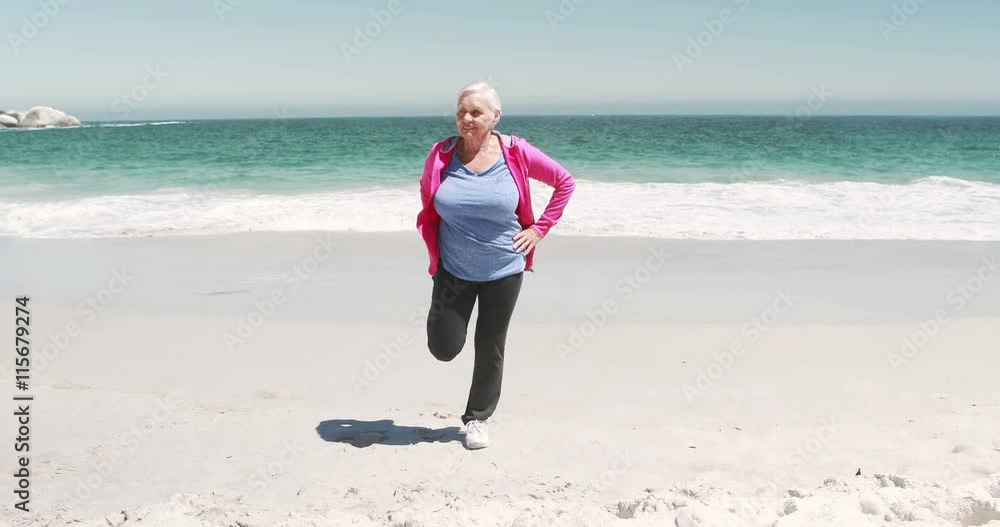 Old retired woman doing some stretching on the beach Old retired woman doing some stretching on the beach