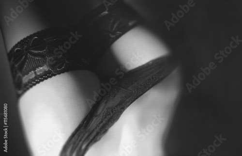 Fragment of black lacy lingerie. The play of light and shadow./Erotic Moments in black / white. Shallow depth of field. photo