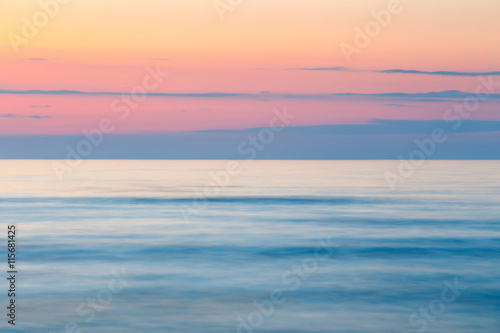 sunset on the beach with a wooden breakwater, long exposure