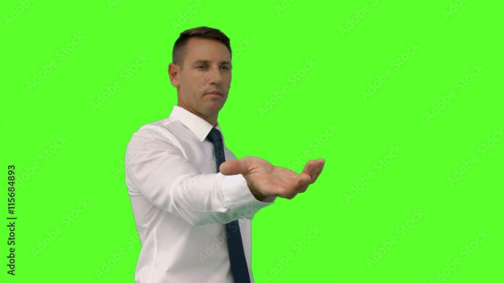 Businessman with his hand out on green screen background Businessman with his hand out on green screen background