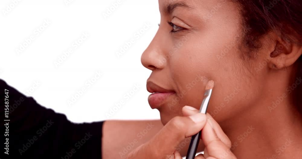 Make up artist putting foundation on models face on white background Make up artist putting foundation on models face on white background