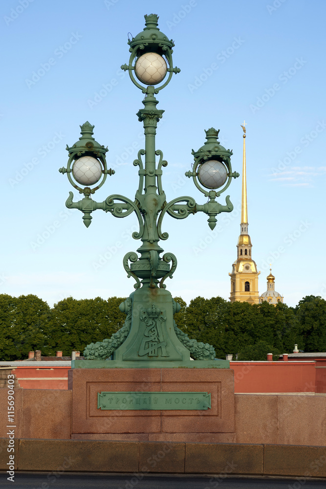 Lantern Trinity Bridge on background the spire of the Peter and Paul Fortress. The inscription 