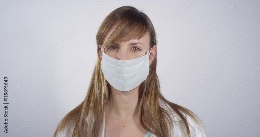 Young doctor putting on surgical mask Young doctor putting on surgical mask