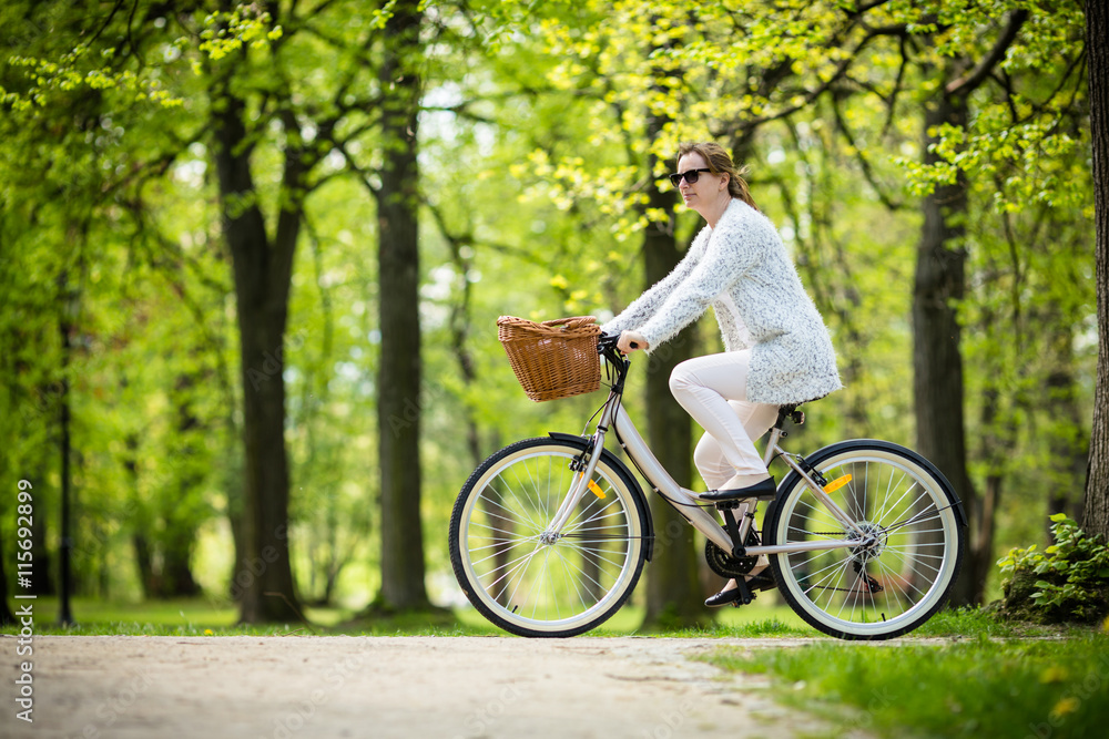 Urban biking - woman riding bike in city park Urban biking - woman riding bike in city park