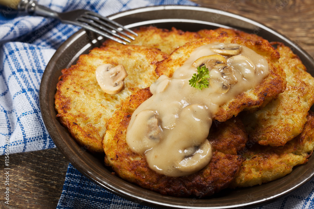 Homemade potato pancakes served with mushroom sauce and mushroom Homemade potato pancakes served with mushroom sauce and mushroom