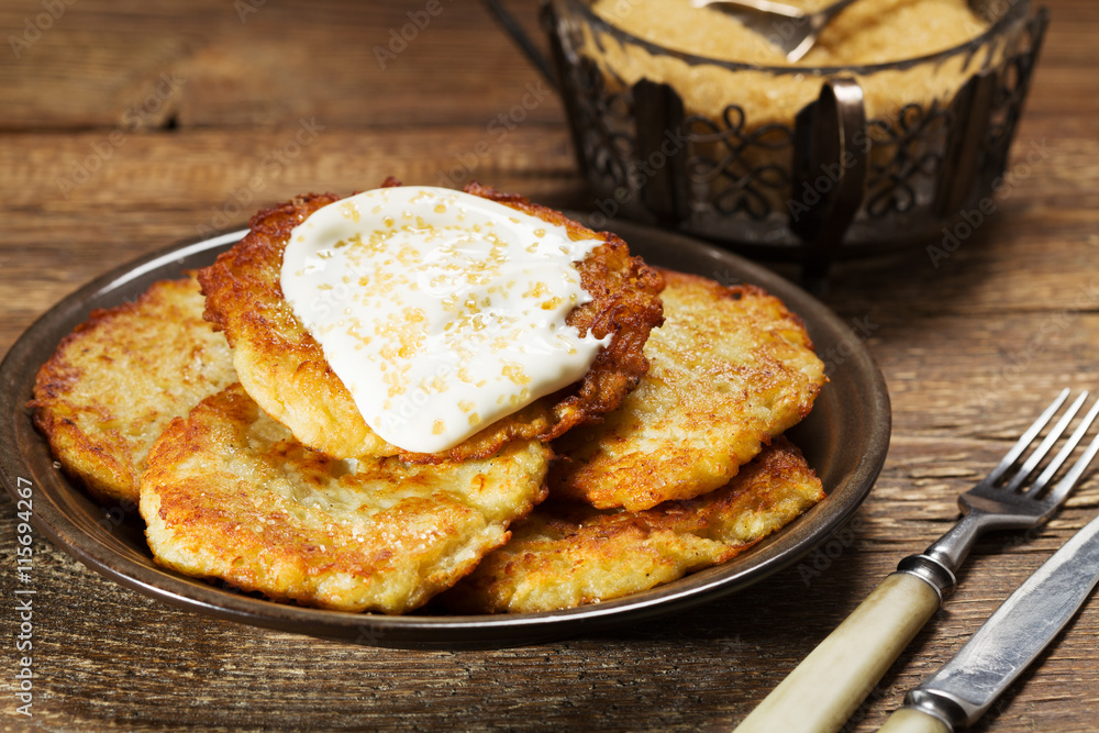 Homemade potato pancakes served with sour cream and brown sugar Homemade potato pancakes served with sour cream and brown sugar