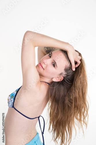 Young caucasian girl posing in swimsuitand hands on hair