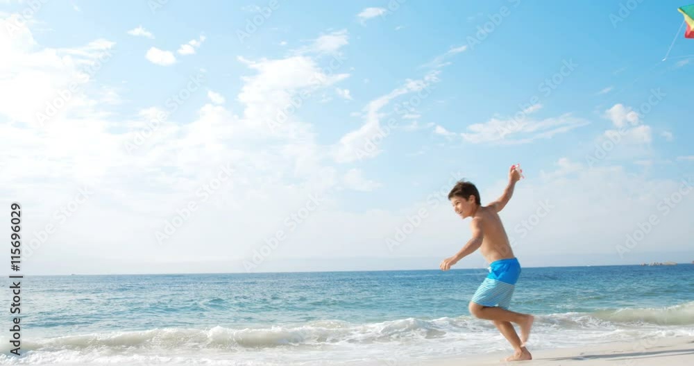 Father and son playing with kite on the beach Father and son playing with kite on the beach