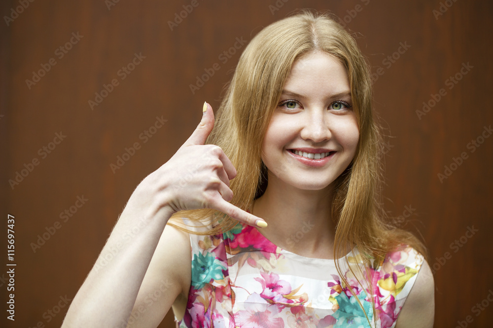 Beautiful woman making a call me gesture Beautiful woman making a call me gesture