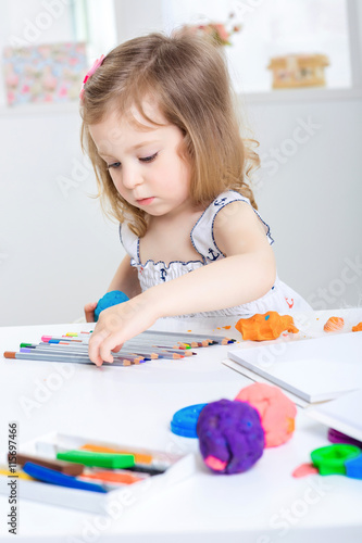  girl playing with colored plasticine