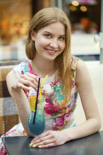 Young woman drinking cocktail in a cafe