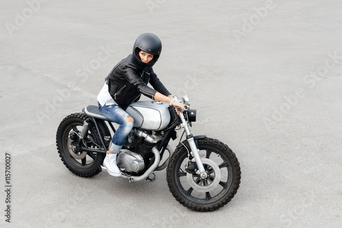 Biker woman in leather jacket on motorcycle