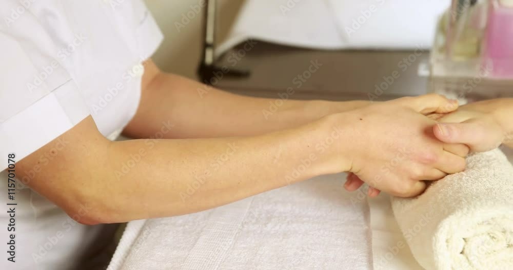 Beauty therapist massaging customers hands at the nail salon Beauty therapist massaging customers hands at the nail salon