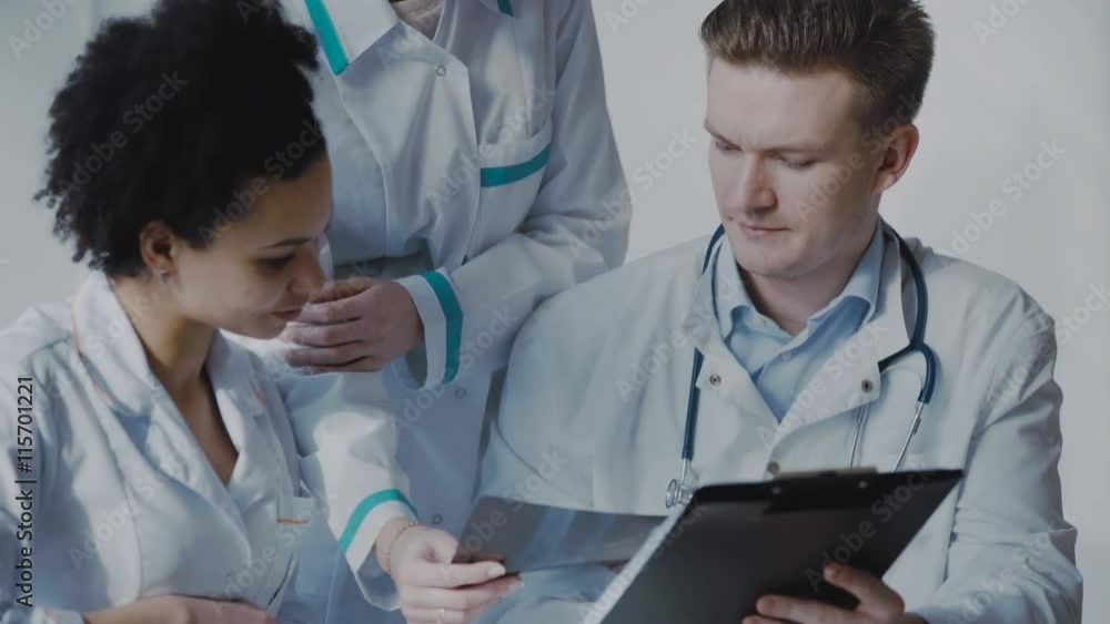 Healthcare, medical: Group of multi-ethnic doctors discuss and looking x-ray in a clinic or hospital. UHD 4K Healthcare, medical: Group of multi-ethnic doctors discuss and looking x-ray in a clinic or hospital. UHD 4K