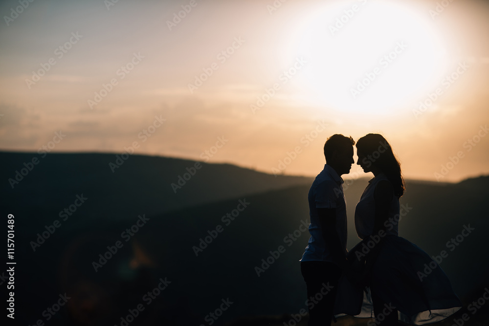 silhouette guy and girl in the mountains